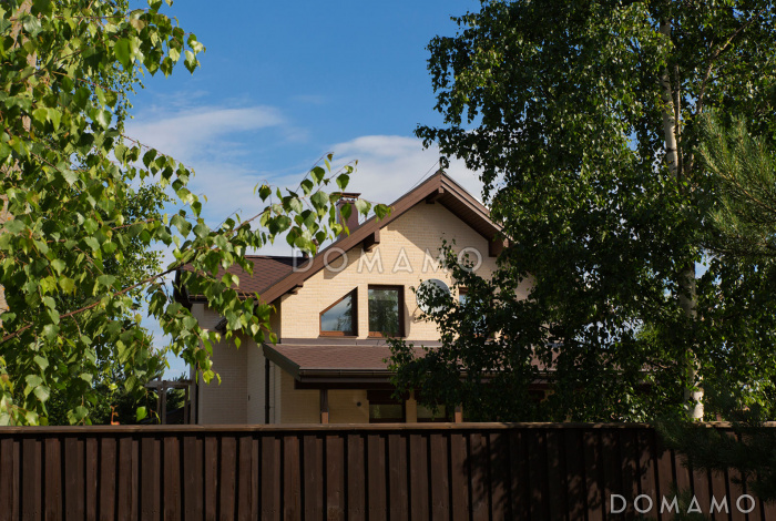 Проект дома из пеноблоков с угловой террасой и просторным балконом на мансардном этаже