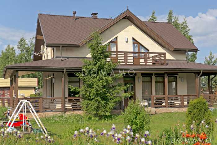 Проект дома из пеноблоков с угловой террасой и просторным балконом на мансардном этаже